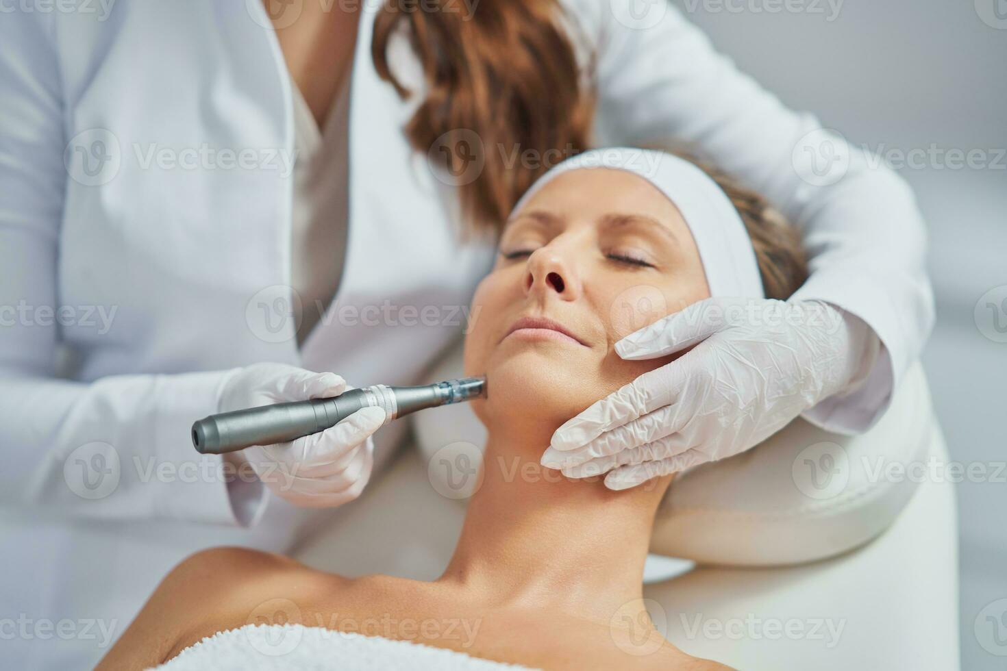 Woman in a beauty salon having needle mesotherapy treatment photo