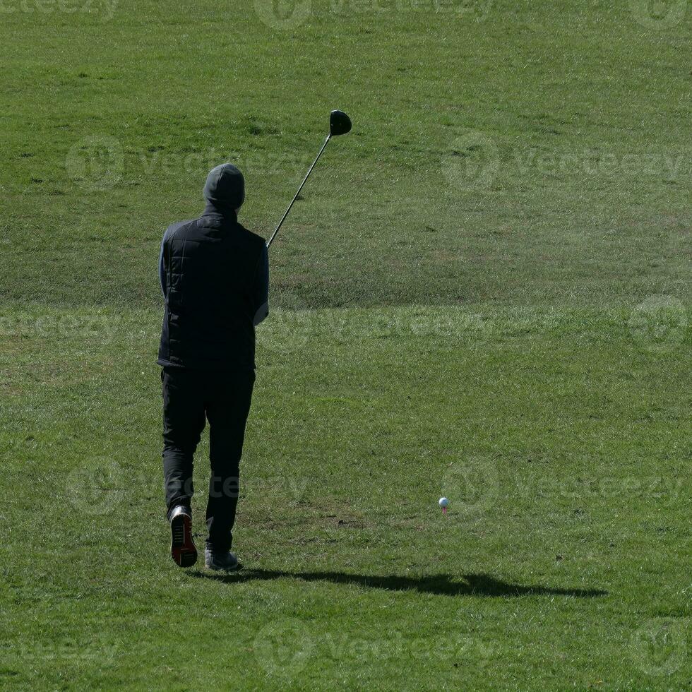 Golfer lining up his stroke photo