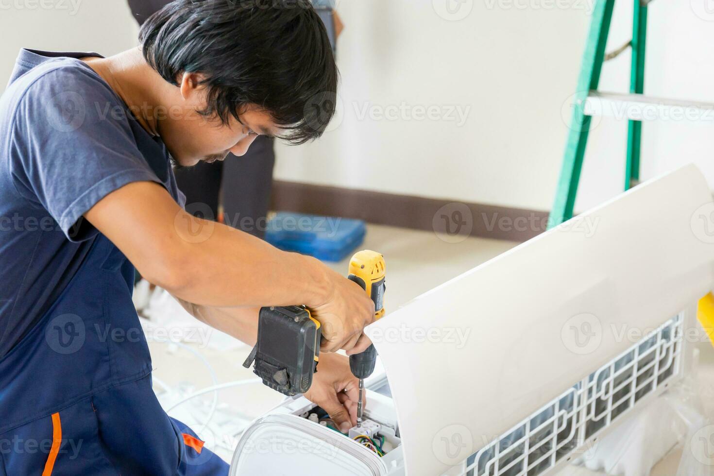 Young repairman team fixing air conditioner unit, Asian technician man installing an air conditioning in a client house, Maintenance and repairing concepts photo