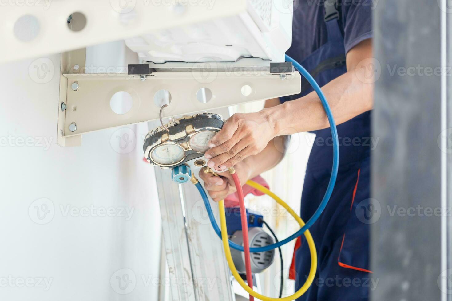 Repairman fixing air conditioner unit, Asian technician man installing an air conditioning in a client house, Maintenance and repairing concepts photo