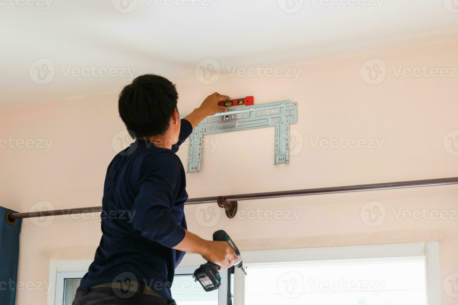 Electrician installing air conditioner unit, Repairman fixing air conditioning, Technician man installing an air conditioner unit in a client house, Maintenance and repairing concepts photo