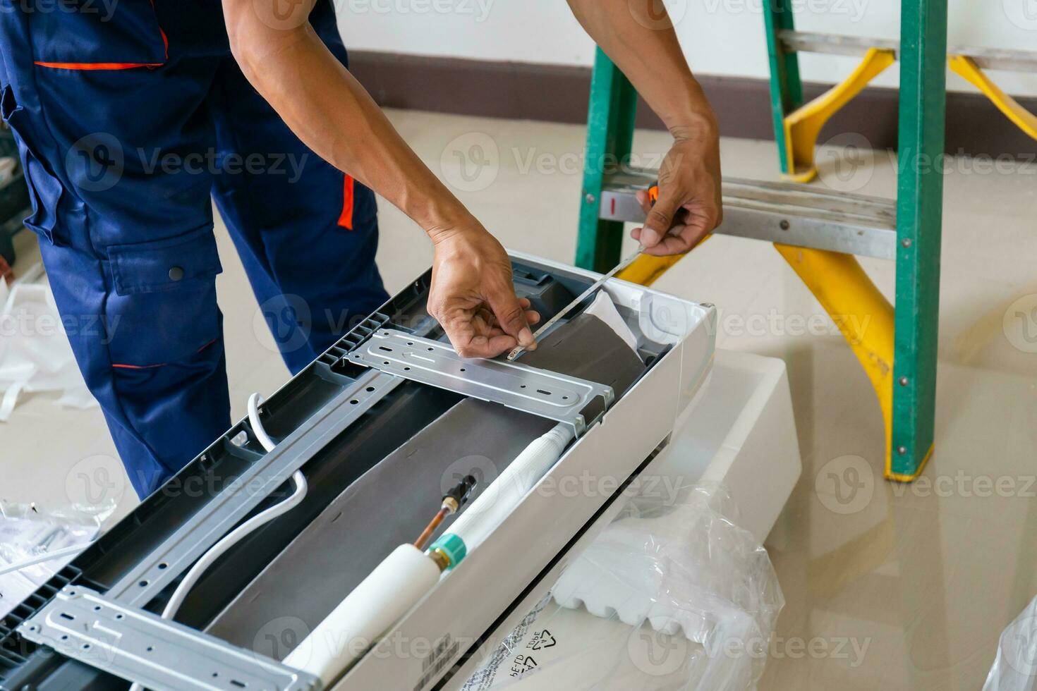 Technician man installing an air conditioning in a client house, Young repairman fixing air conditioner unit, Maintenance and repairing concepts photo