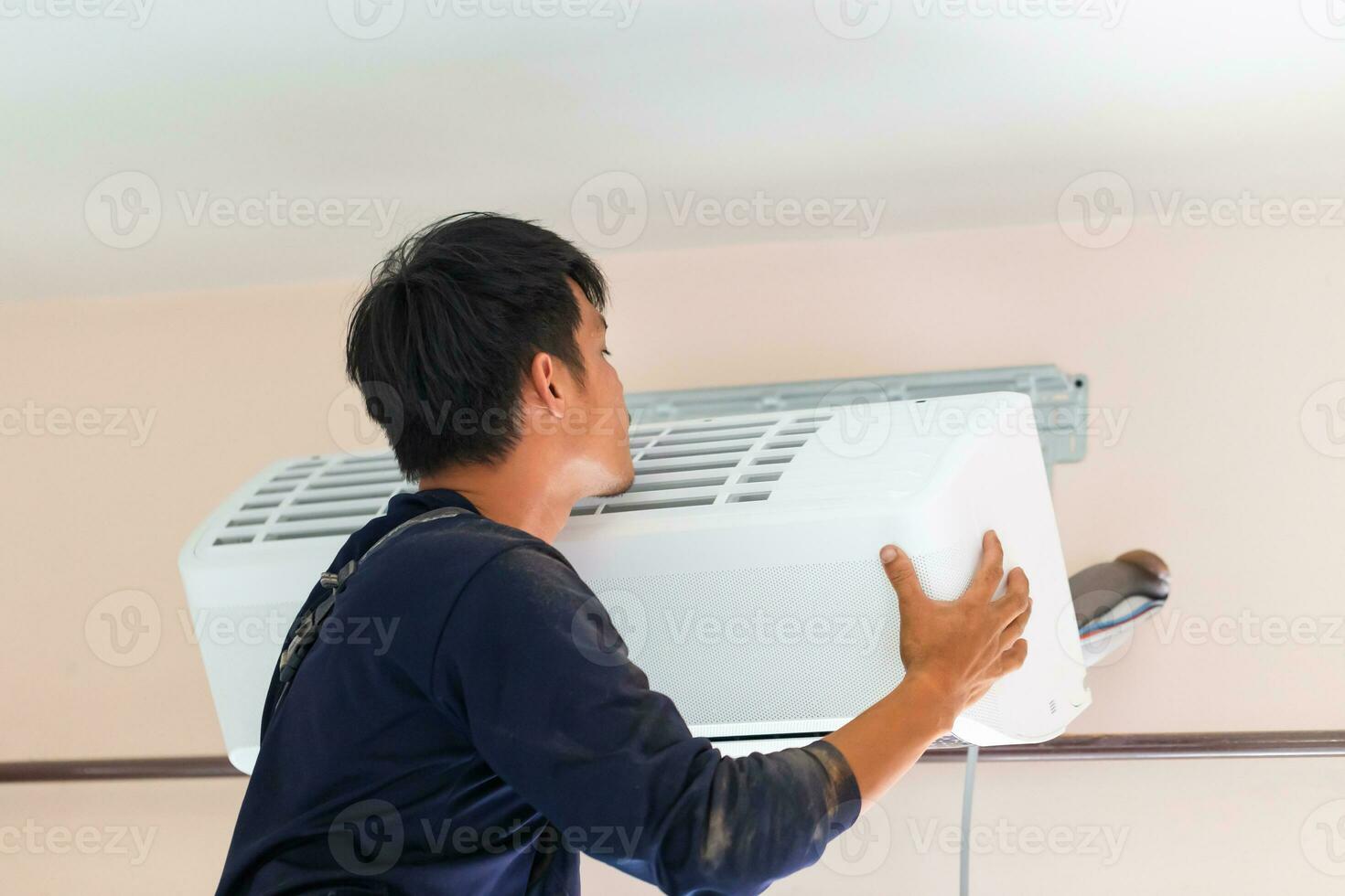 Electrician installing air conditioner unit, Technician man installing an air conditioning in a client house, Repairman fixing air conditioner unit, Maintenance and repairing concepts photo