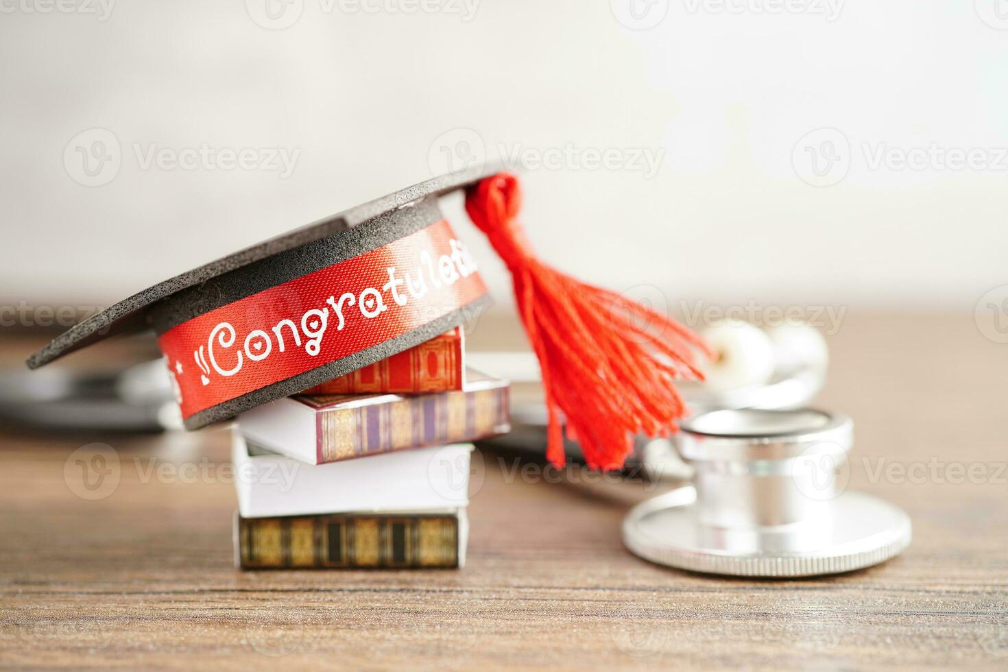 Graduation hat on book and stethoscope with copy space, doctor learning medicine university education concept. photo