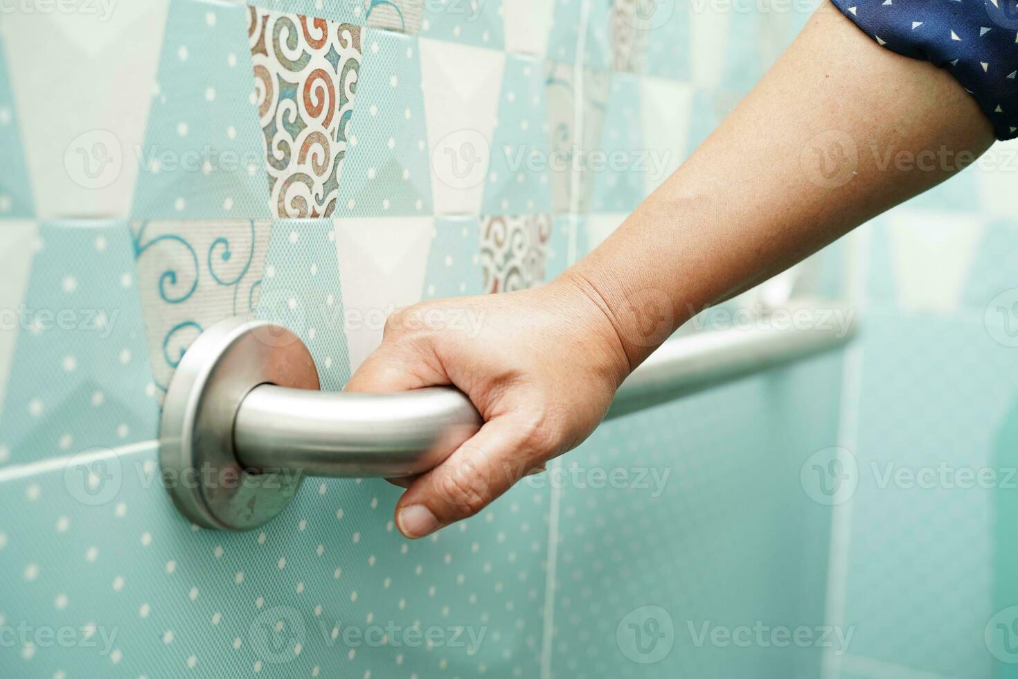 Asian woman patient use toilet support rail in bathroom, handrail safety grab bar, security in nursing hospital. photo