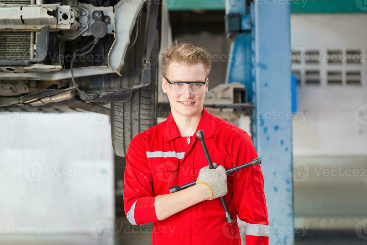 alegre el mecánico hombre en reparar cochera, técnico hombre trabajando en auto reparar comercio, coche reparar y mantenimiento conceptos foto