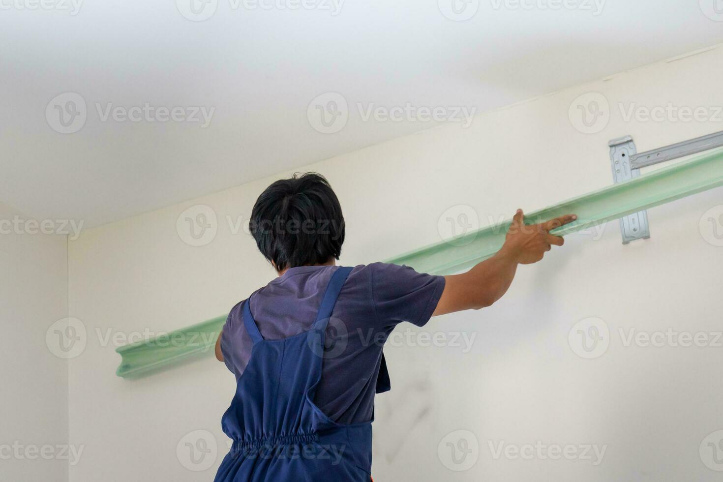 Young repairman fixing air conditioner unit, Asian technician man installing an air conditioning in a client house, Maintenance and repairing concepts photo