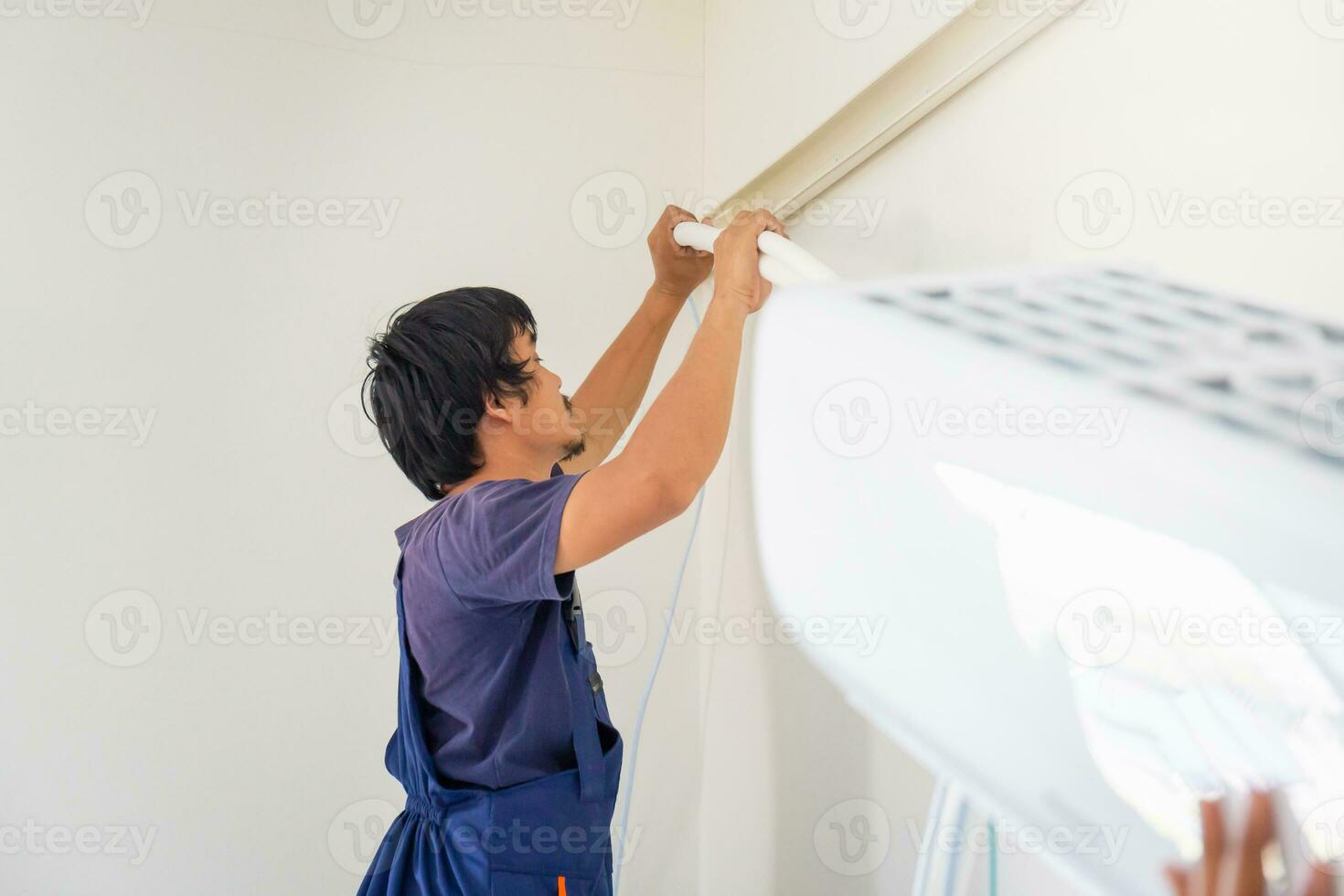 Electrician installing air conditioner unit, Technician man installing an air conditioning in a client house, Repairman fixing air conditioner unit, Maintenance and repairing concepts photo