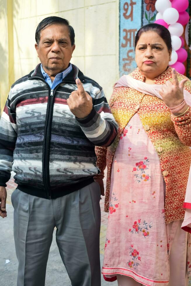New Delhi, India - March 04 2023 - Unidentified people showing their ink-marked fingers after casting votes in front of polling booth of east Delhi area for MCD local body Elections 2022 photo