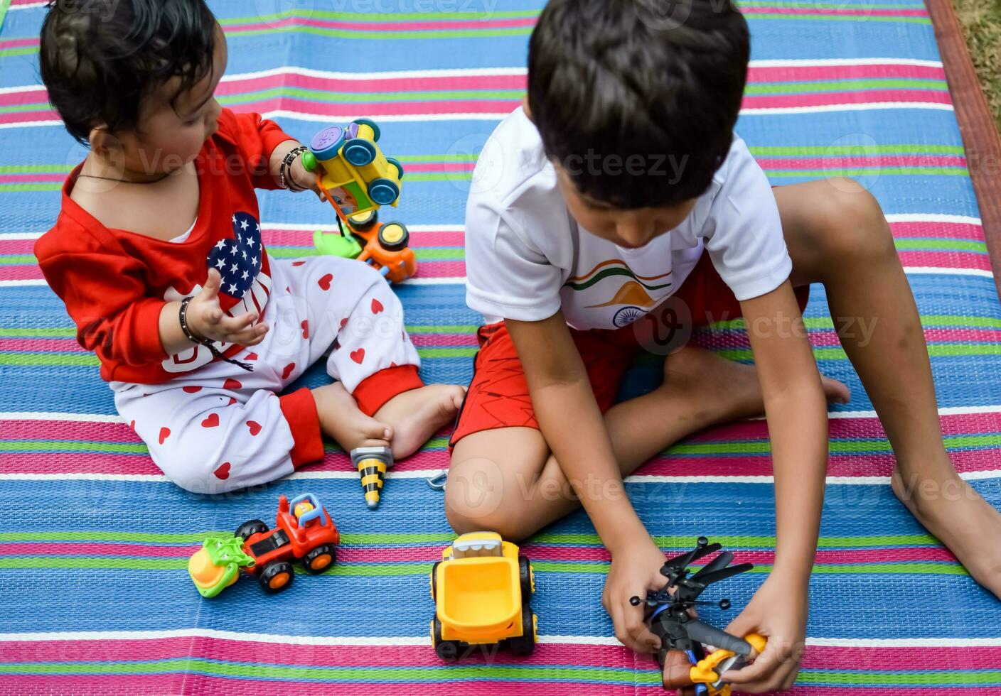 dos contento Niños en sociedad parque, contento asiático hermanos quien son sonriente felizmente juntos. hermanos jugar al aire libre en verano, mejor amigos. niñito bebé chico jugando con su contento hermano en el jardín foto