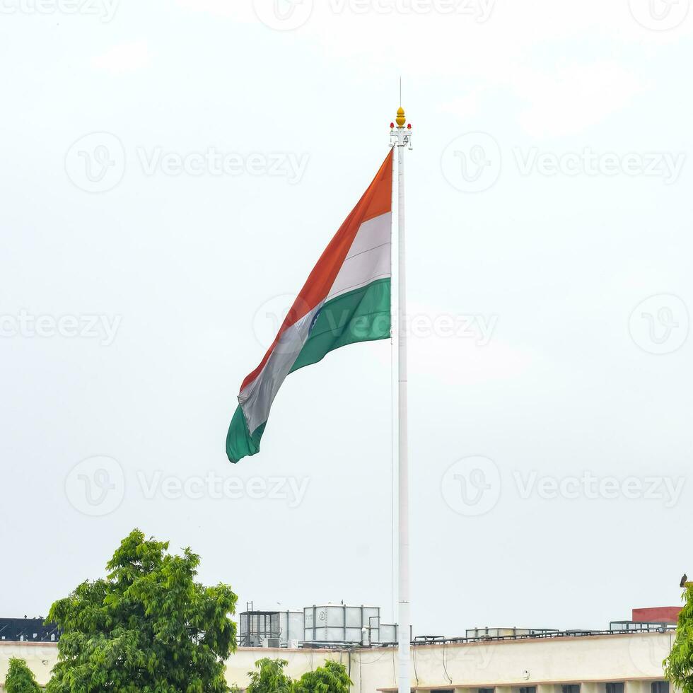 India flag flying high at Connaught Place with pride in blue sky, India flag fluttering, Indian Flag on Independence Day and Republic Day of India, tilt up shot, Waving Indian flag, Har Ghar Tiranga photo