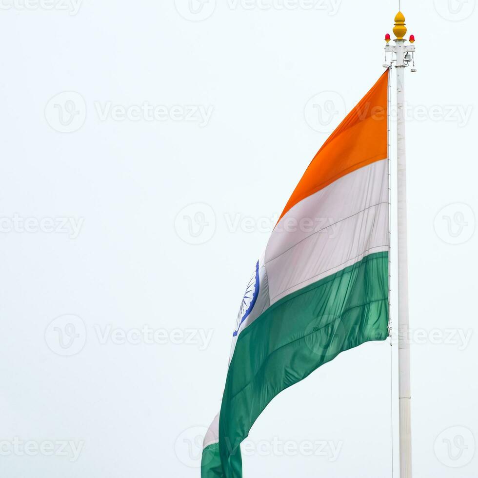 India flag flying high at Connaught Place with pride in blue sky, India flag fluttering, Indian Flag on Independence Day and Republic Day of India, tilt up shot, Waving Indian flag, Har Ghar Tiranga photo