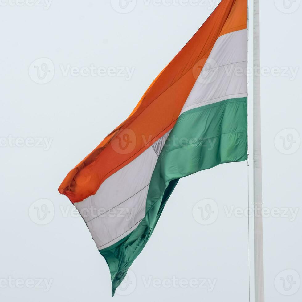 India flag flying high at Connaught Place with pride in blue sky, India flag fluttering, Indian Flag on Independence Day and Republic Day of India, tilt up shot, Waving Indian flag, Har Ghar Tiranga photo