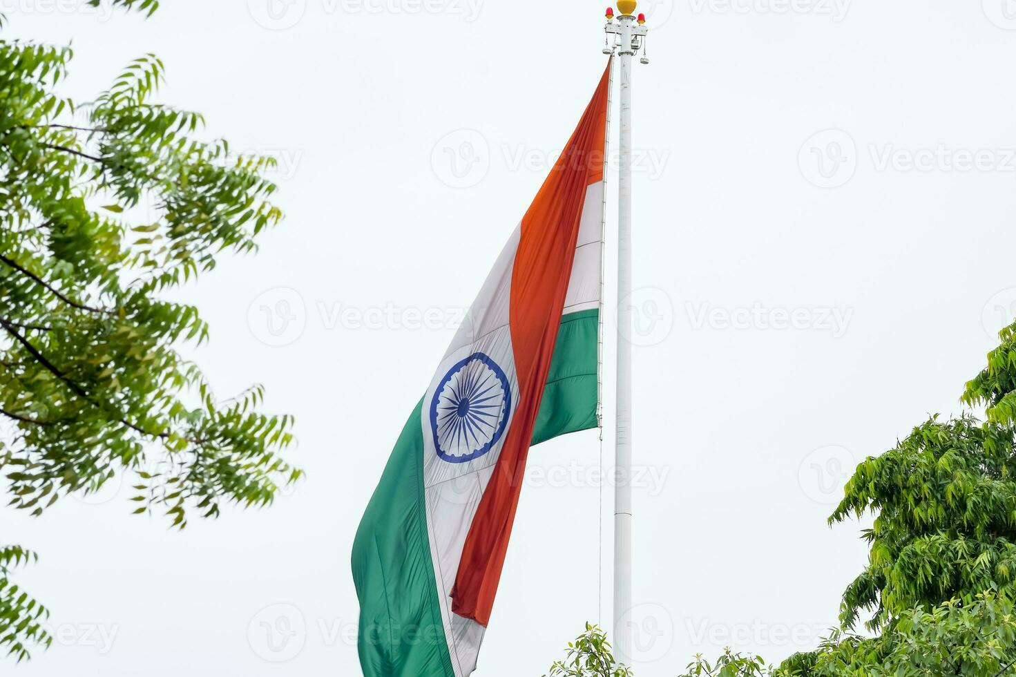 India flag flying high at Connaught Place with pride in blue sky, India flag fluttering, Indian Flag on Independence Day and Republic Day of India, tilt up shot, Waving Indian flag, Har Ghar Tiranga photo