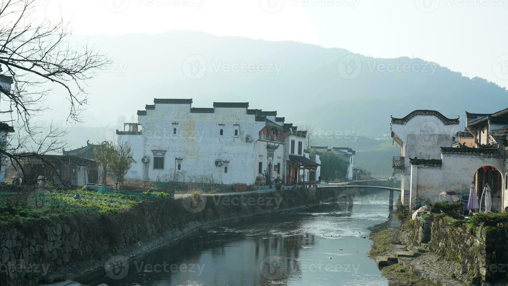 One old traditional Chinese village view with the old arched stone bridge and old wooden buildings in the Southern countryside of the China photo