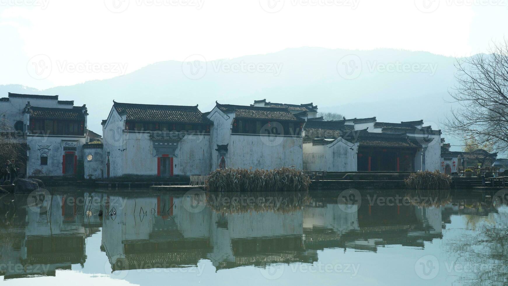 One old traditional Chinese village view with the old arched stone bridge and old wooden buildings in the Southern countryside of the China photo