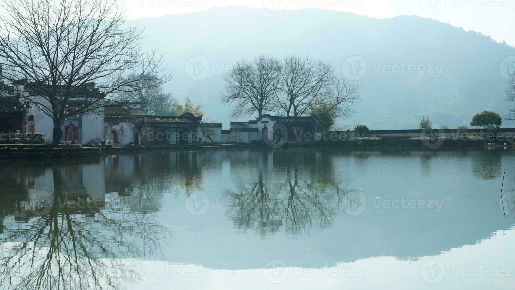 One old traditional Chinese village view with the old arched stone bridge and old wooden buildings in the Southern countryside of the China photo
