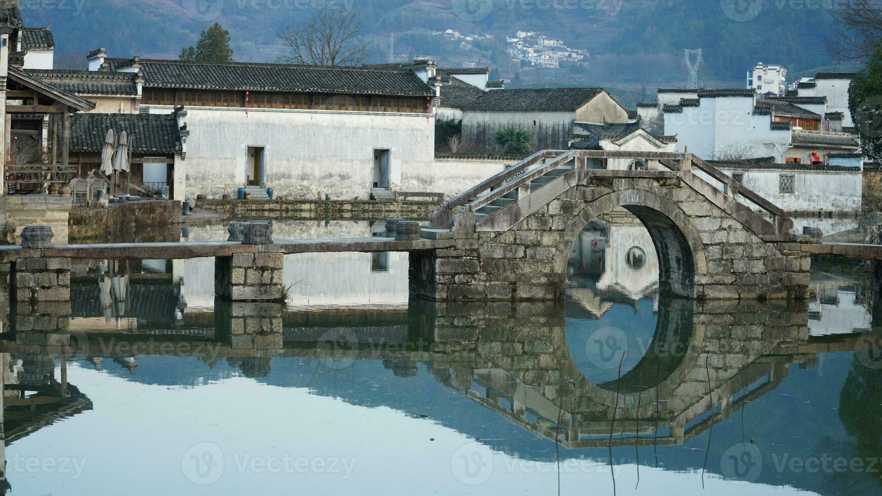 One old traditional Chinese village view with the old arched stone bridge and old wooden buildings in the Southern countryside of the China photo