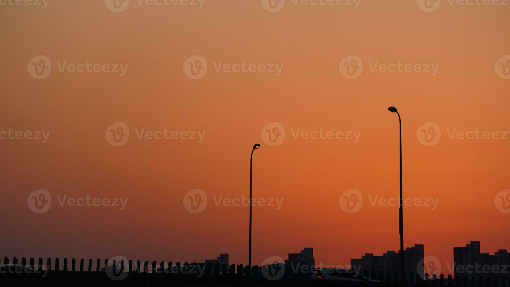 The beautiful sunset view with the buildings' silhouette and orange color sky as background in the city photo