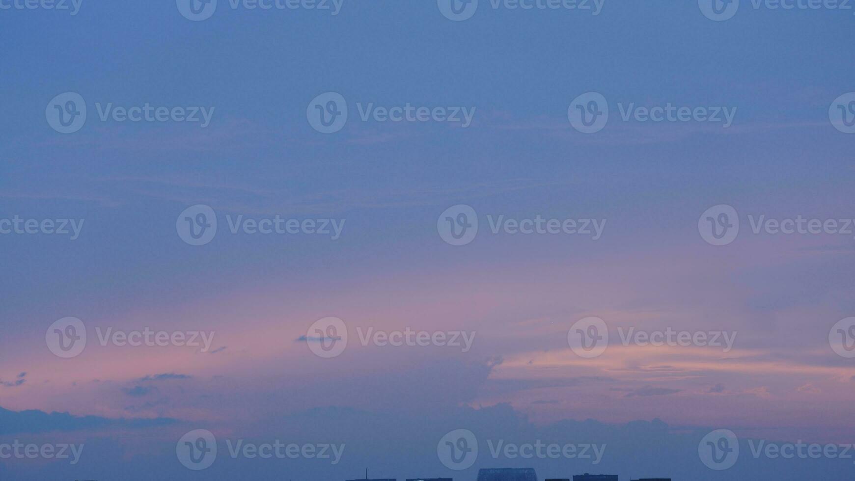 The beautiful sunset view with the buildings' silhouette and orange color sky as background in the city photo