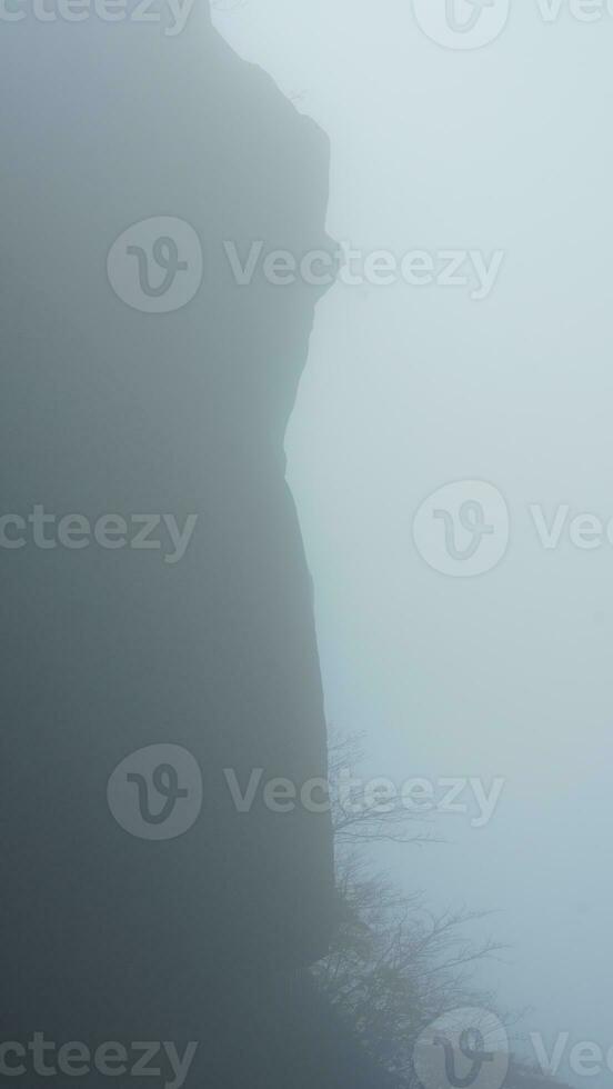 The beautiful mountains view surrounded by the misty fog in winter photo