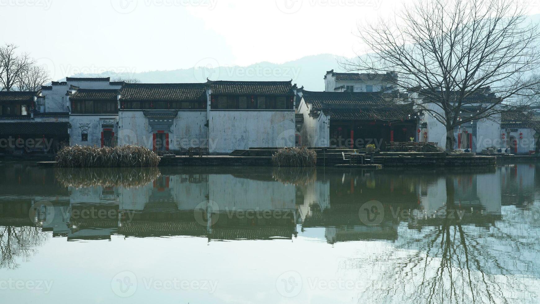 One old traditional Chinese village view with the old arched stone bridge and old wooden buildings in the Southern countryside of the China photo