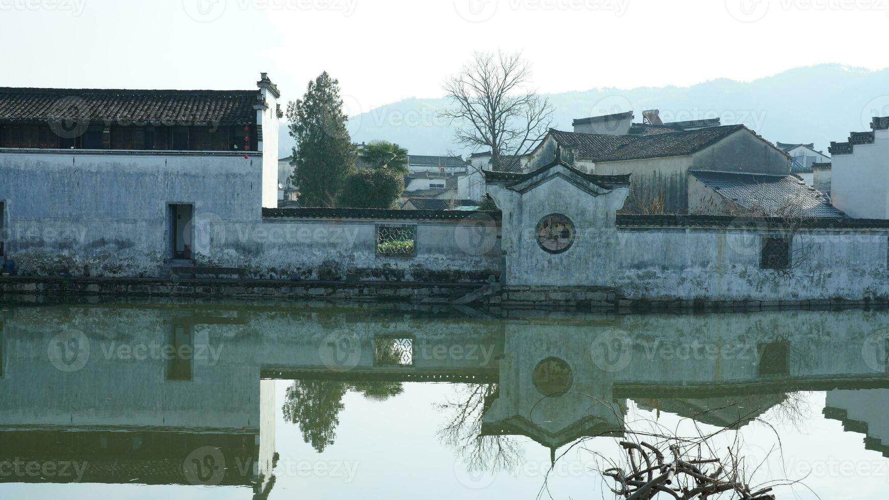 One old traditional Chinese village view with the old arched stone bridge and old wooden buildings in the Southern countryside of the China photo