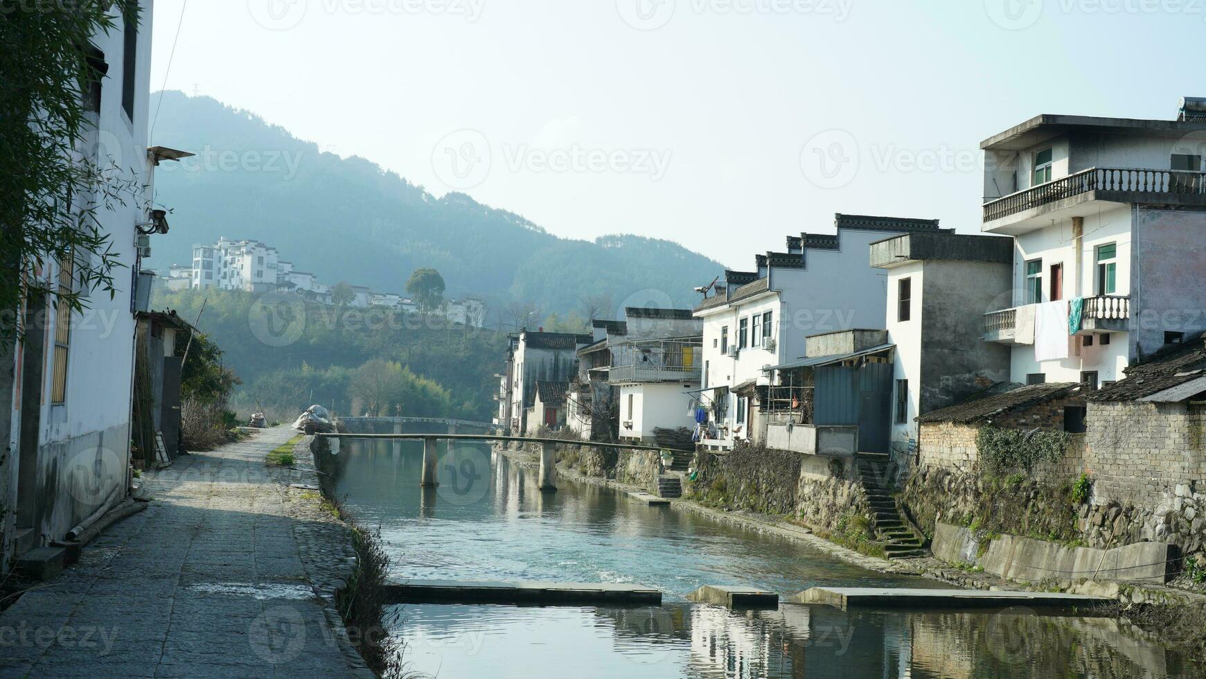 One old traditional Chinese village view with the old arched stone bridge and old wooden buildings in the Southern countryside of the China photo