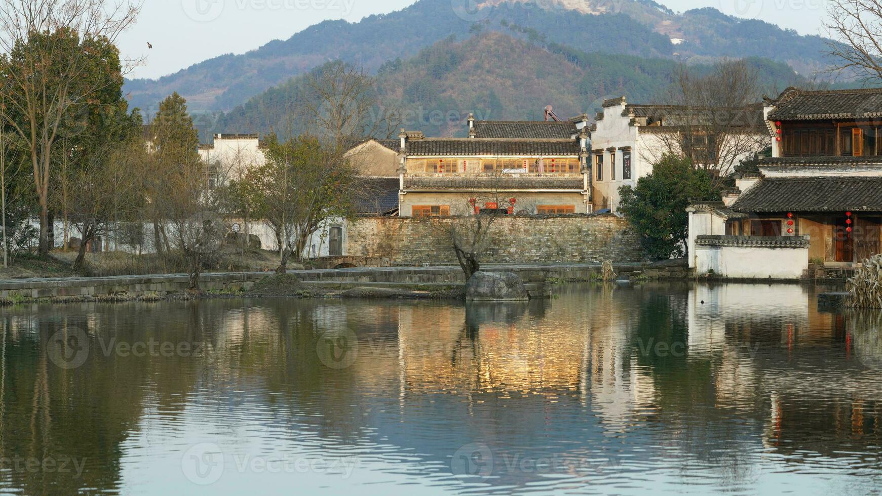 The beautiful traditional Chinese village view with the classical architecture and fresh green trees as background photo