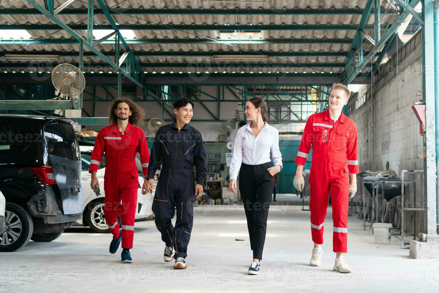 Young confident managers and car mechanics team in uniform are working in auto service. Car repair and maintenance concepts photo