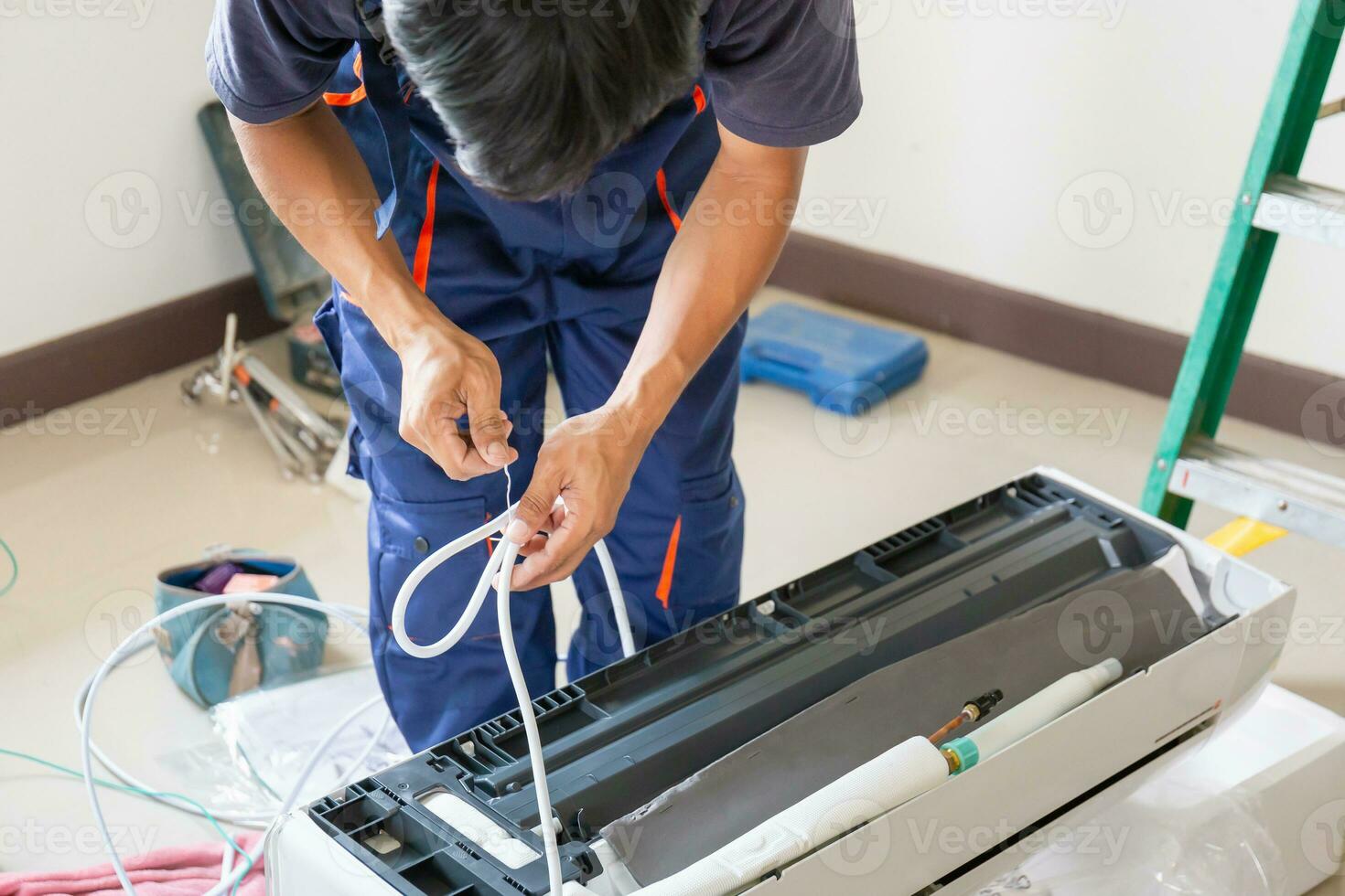 Technician man installing air conditioning in a client house, Young repairman fixing air conditioner unit, Maintenance and repairing concepts photo