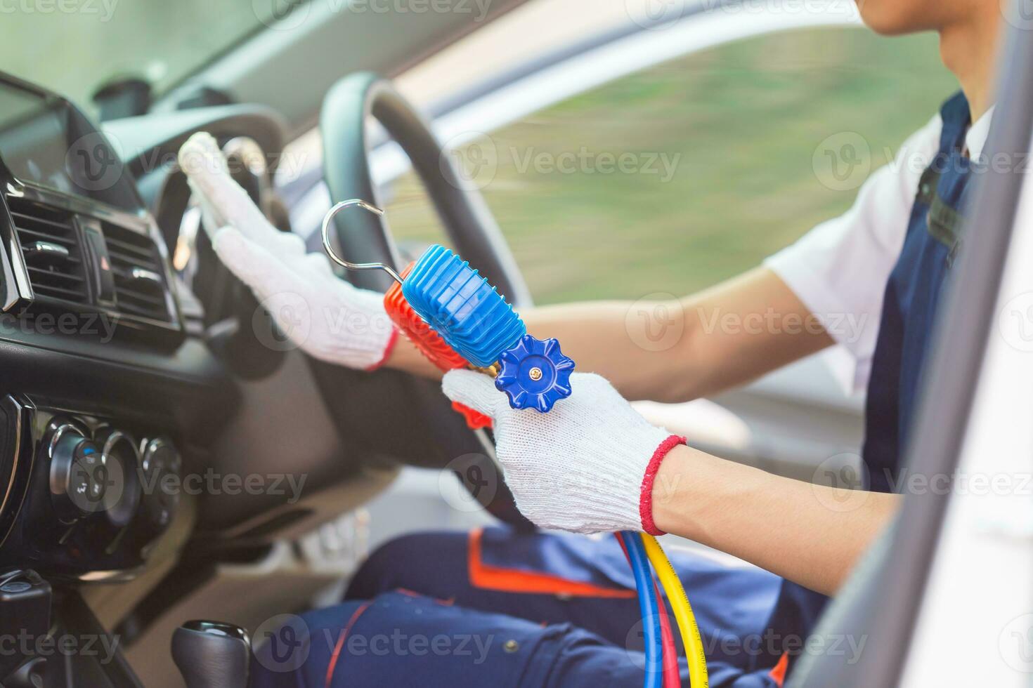 Repairman holding monitor tool to check and fixed car air conditioner system, Technician check car air conditioning system refrigerant recharge, Air Conditioning Repair photo