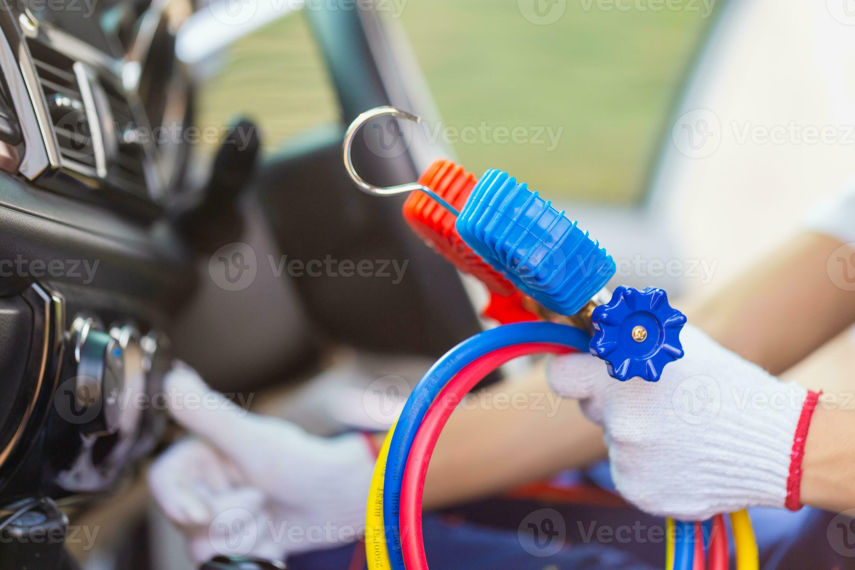 Repairman holding monitor tool to check and fixed car air conditioner