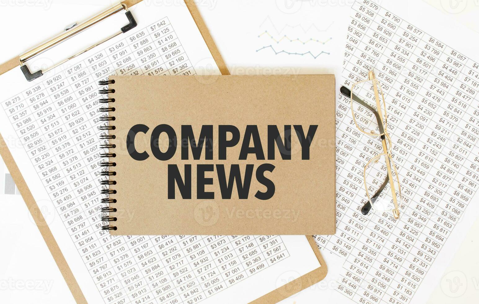 Craft colour notepad with text COMPANY NEWS. Notepad with eyeglasses and text documents. Business concept photo