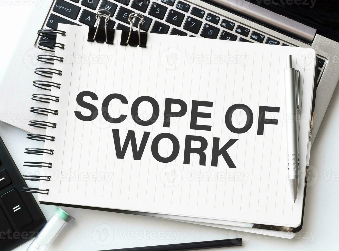 Keyboard of laptop, calculator, pencil and notepad with text scope of work on the white background photo