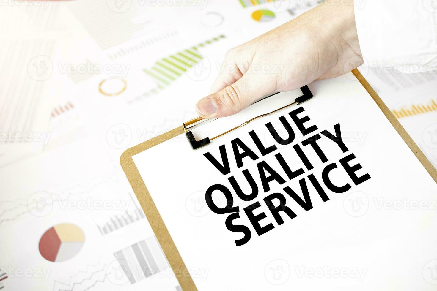 Text value quality service on white paper plate in businessman hands with financial diagram. Business concept photo