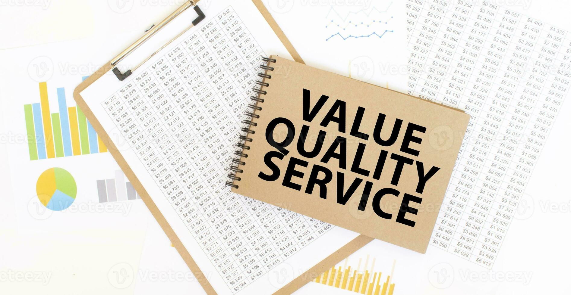 Text value quality service on brown paper notepad on the table with diagram. Business concept photo