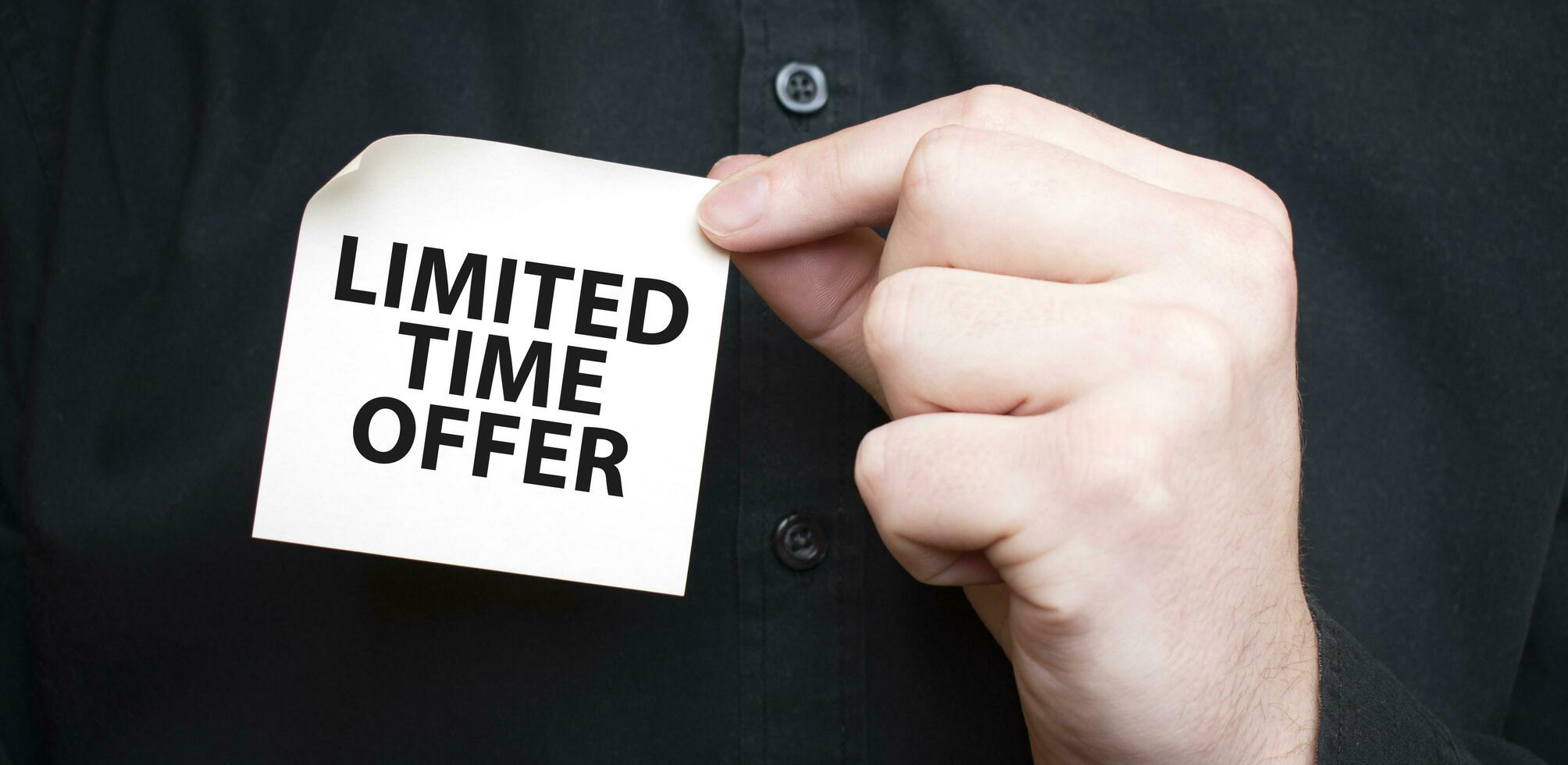 Businessman holding a card with text LIMITED TIME OFFER, business concept photo