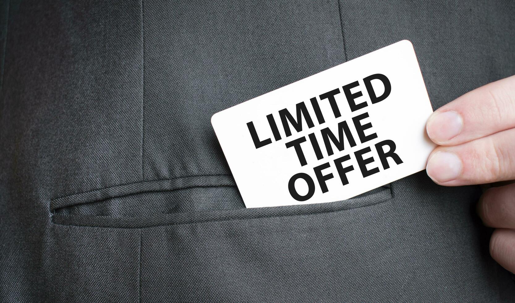 Card with LIMITED TIME OFFER text in pocket of businessman suit. Investment and decisions business concept. photo