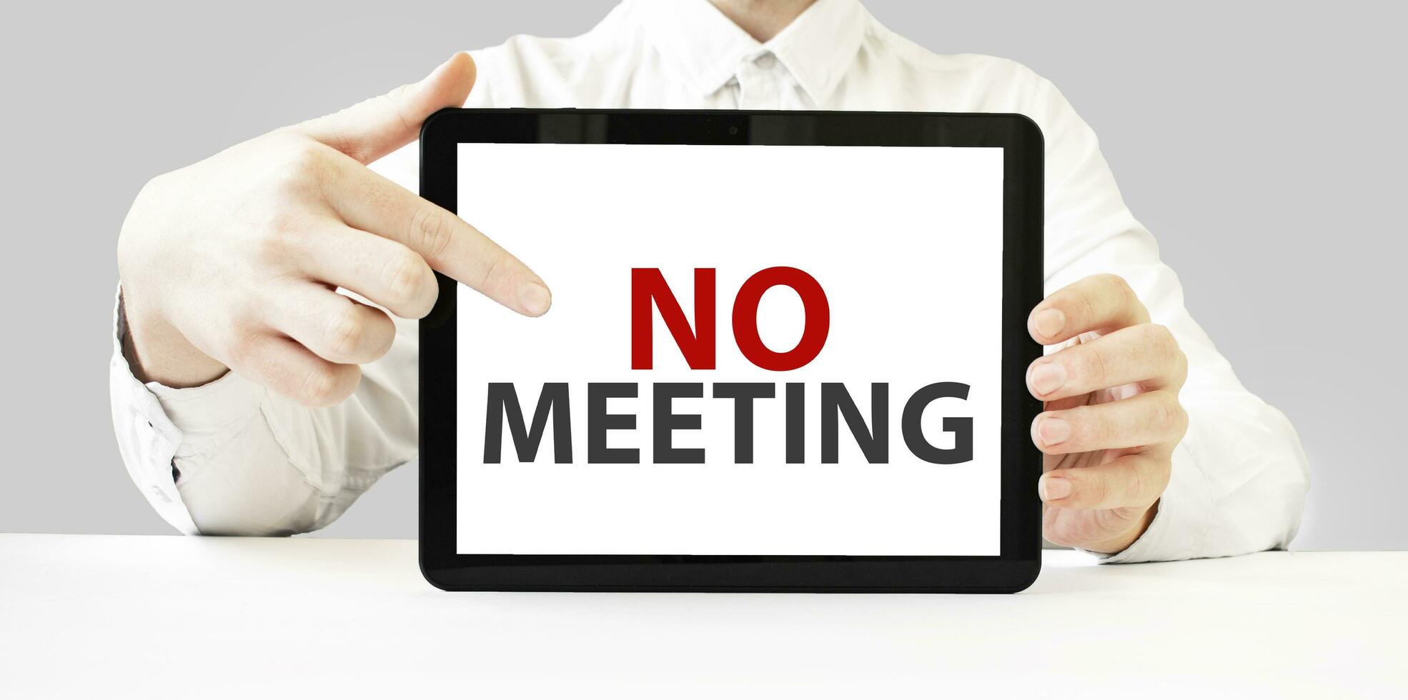 Text no meeting on tablet display in businessman hands on the white background. Business concept photo