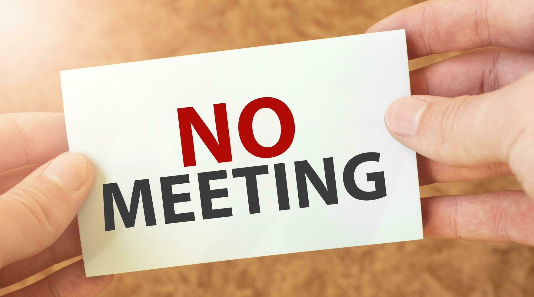 no meeting word inscription on white card paper sheet in hands of a businessman. recap concept. red and white paper photo