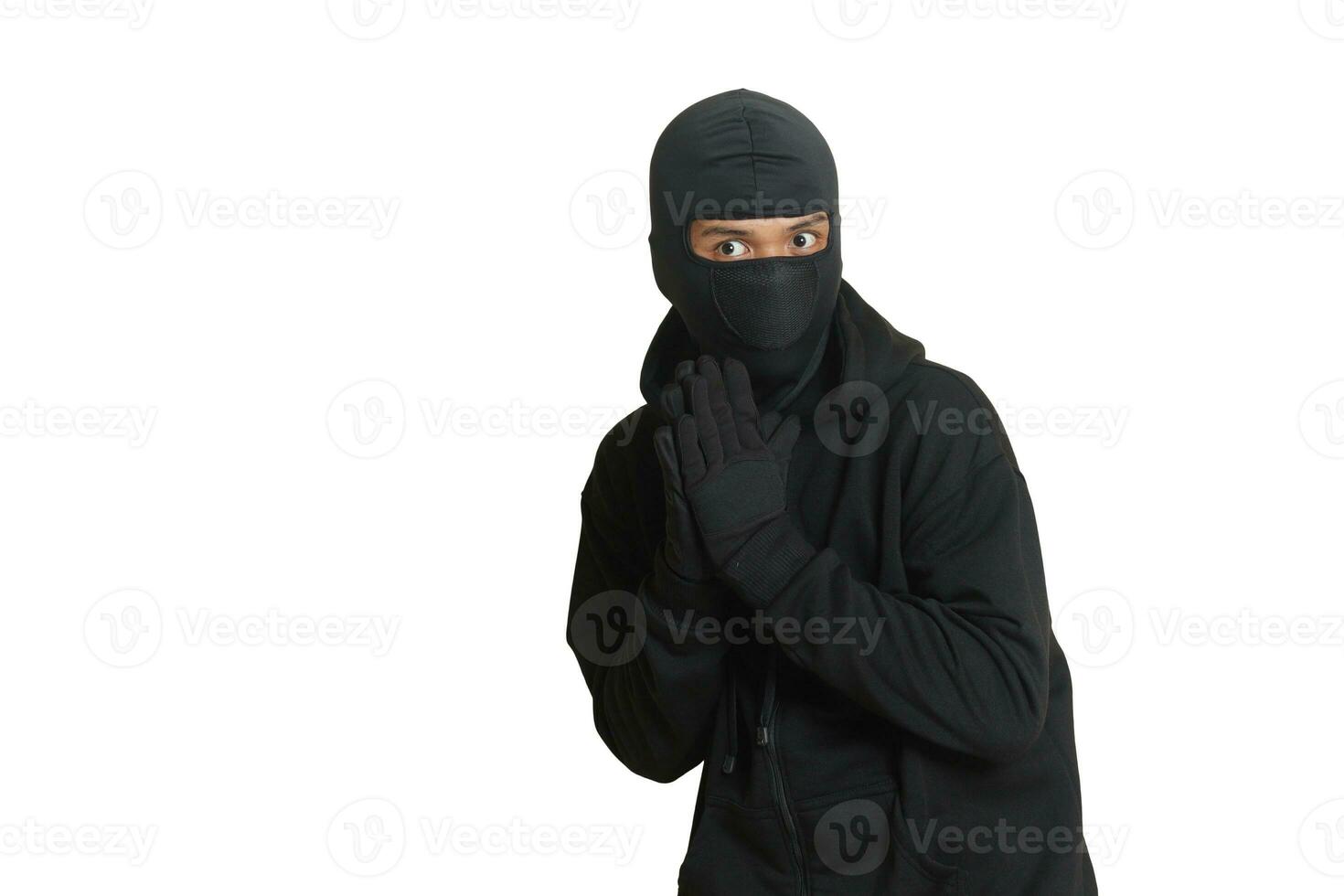 Mysterious man wearing black hoodie standing and looking at camera. Isolated image on gray background photo