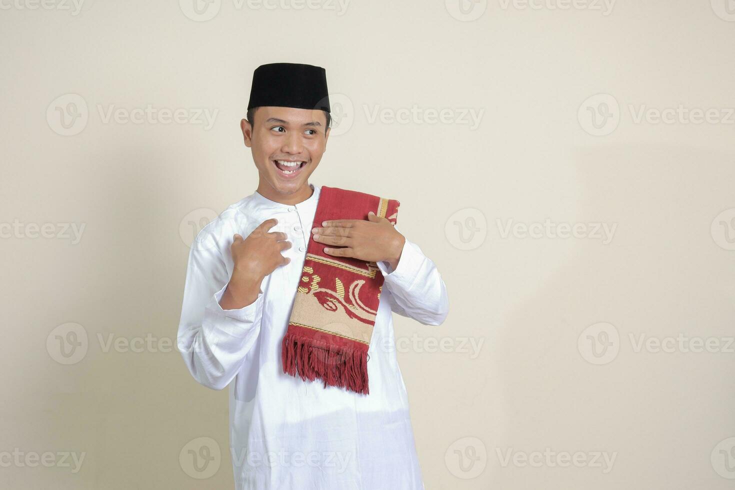Portrait of attractive Asian muslim man in white shirt pulling hands towards camera, inviting someone to come inside, welcoming gesture. Isolated image on gray background photo