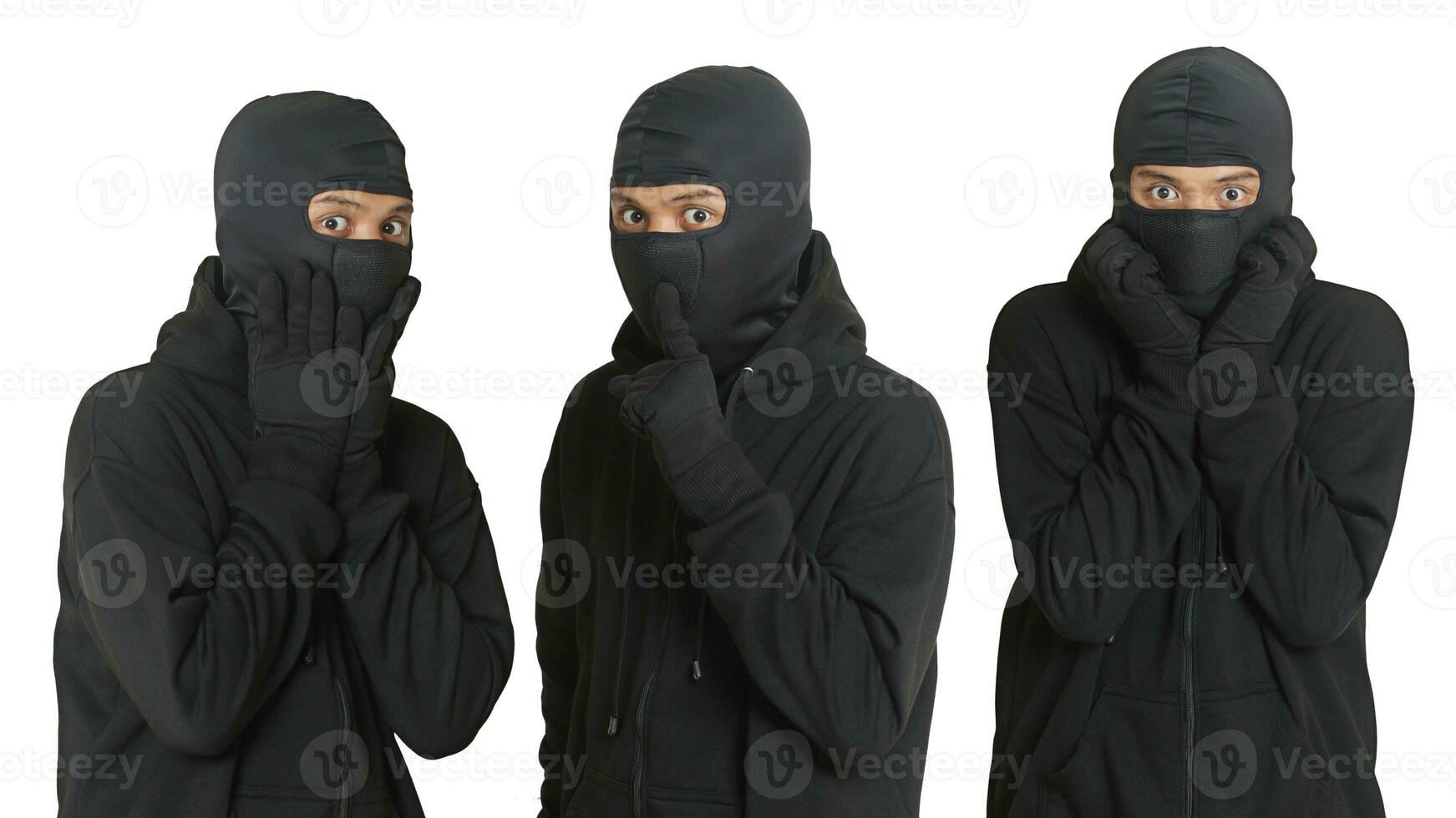 Mysterious thief man wearing black hoodie and mask was caught while sneaking around. Shocked and frightened criminal. Isolated image on gray background photo