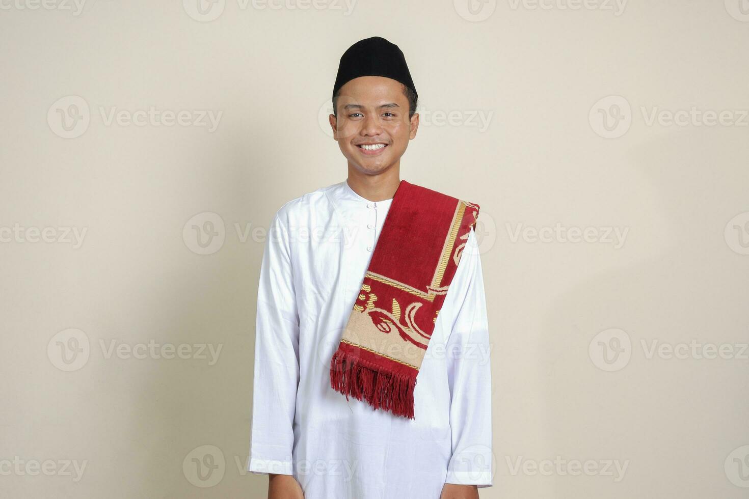 Portrait of attractive Asian muslim man in white shirt feeling confident, smiling and looking at camera. Isolated image on gray background photo