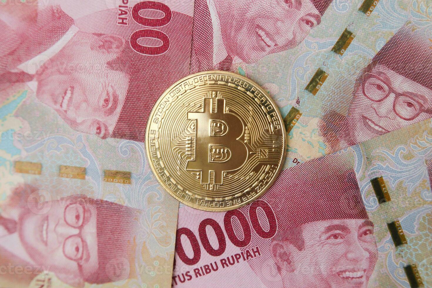 Bitcoin placing on the top of one hundred thousand rupiah bank note. Cryptocurrency trading concept photo