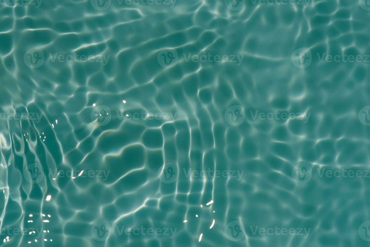 Green water with ripples on the surface. Defocus blurred transparent blue colored clear calm water surface texture with splashes and bubbles. Water waves with shining pattern texture background. photo
