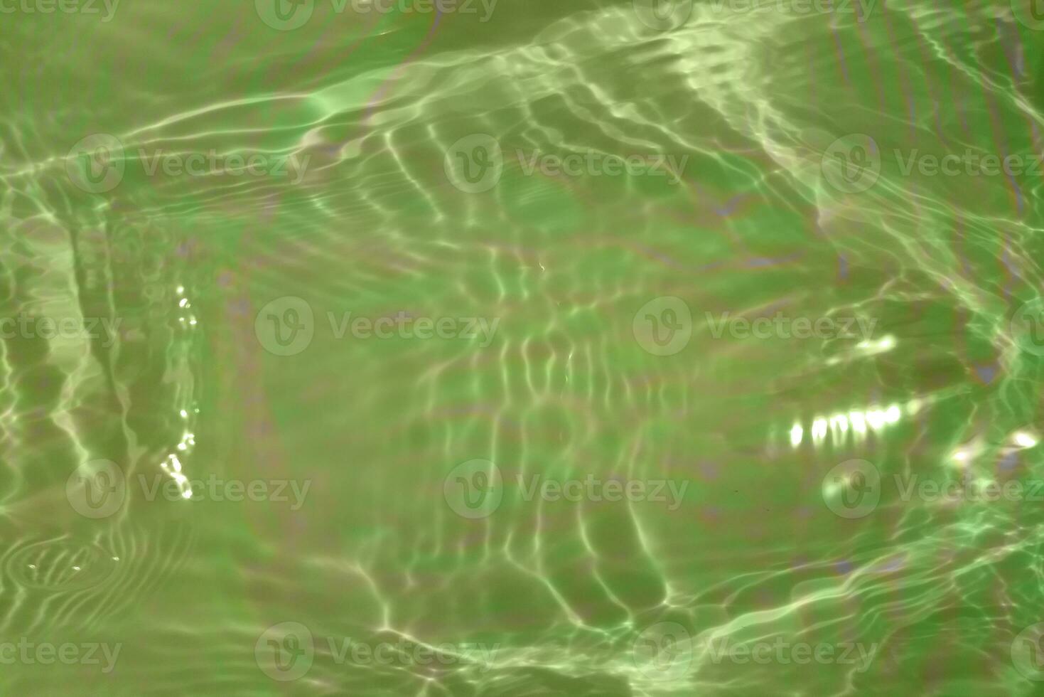 Light green water with ripples on the surface. Defocus blurred transparent colored clear calm water surface texture with splashes and bubbles. Water waves with shining pattern texture background. photo