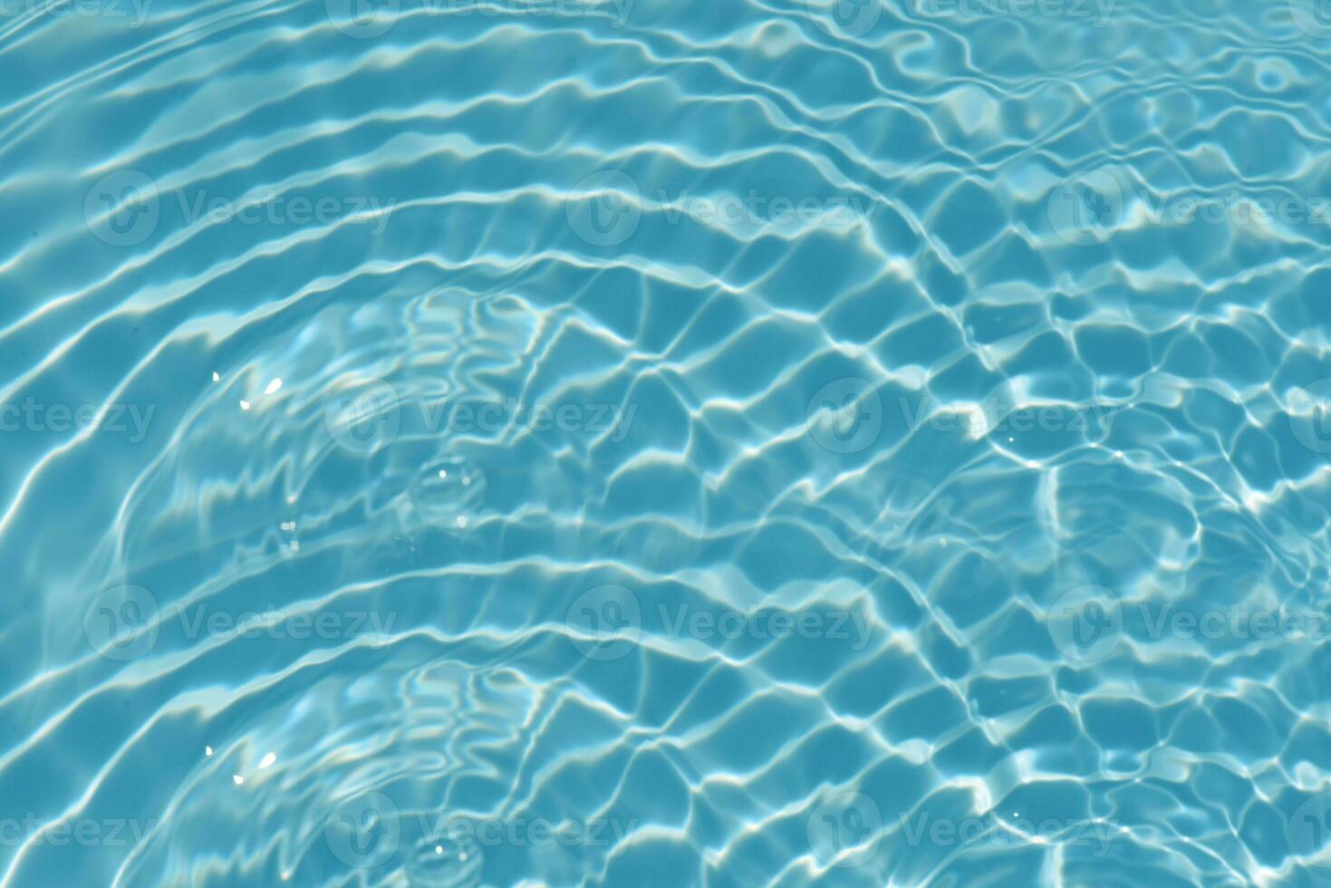 Blue water with ripples on the surface. Defocus blurred transparent blue colored clear calm water surface texture with splashes and bubbles. Water waves with shining pattern texture background. photo