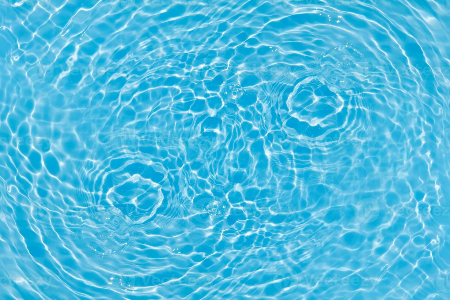 Blue water with ripples on the surface. Defocus blurred transparent blue colored clear calm water surface texture with splashes and bubbles. Water waves with shining pattern texture background. photo